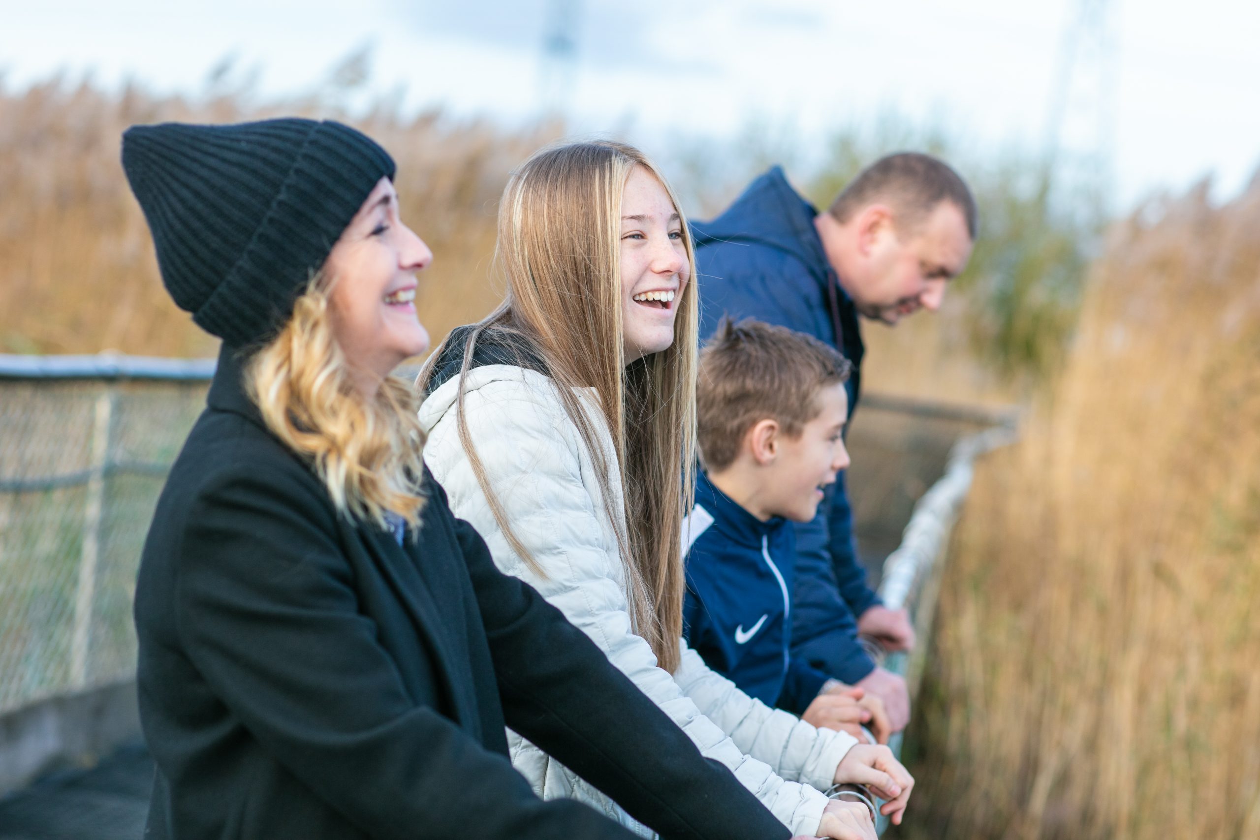 family having a photo together looking off a bridge