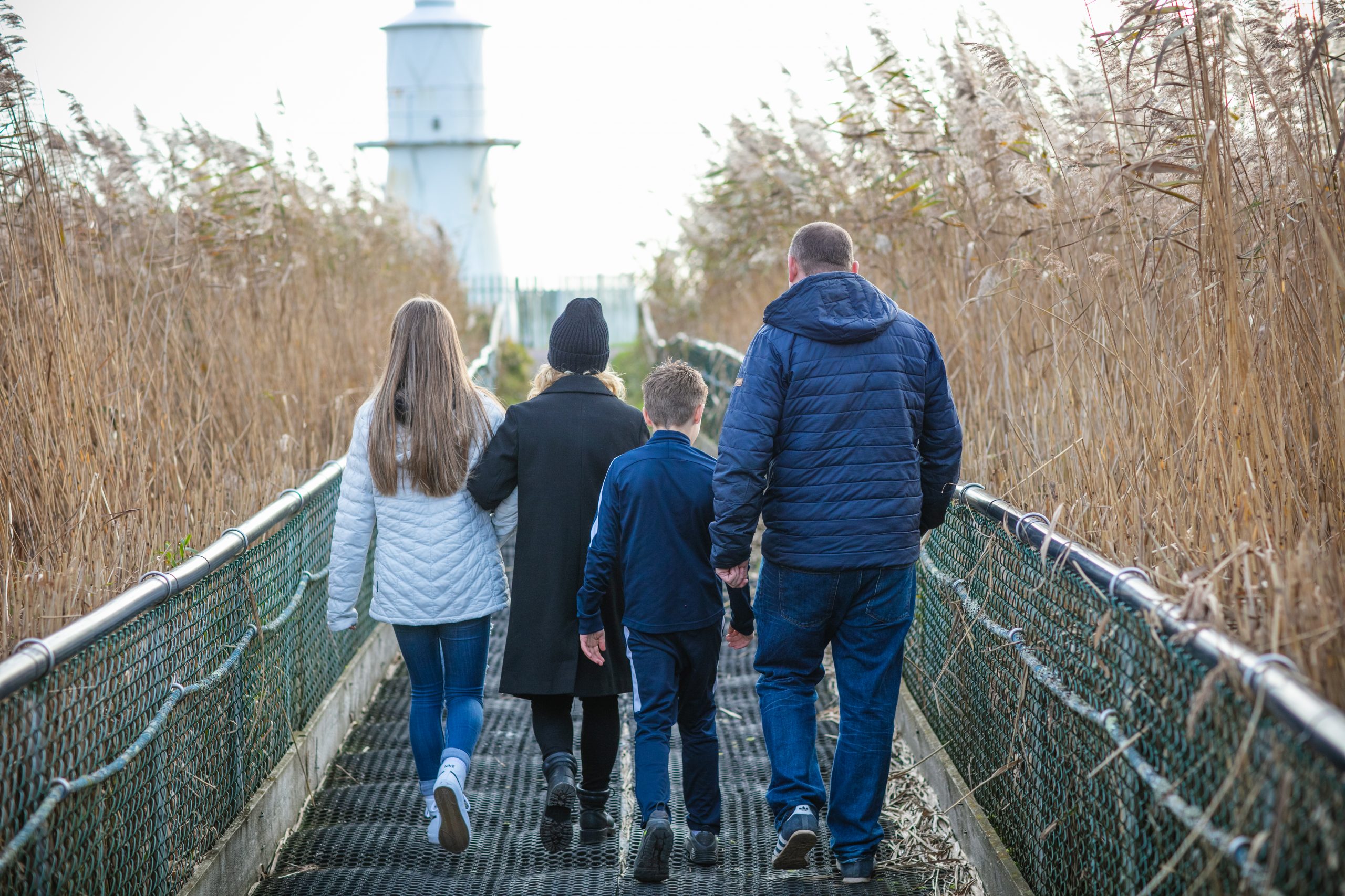 family walking away from camera on a bridge